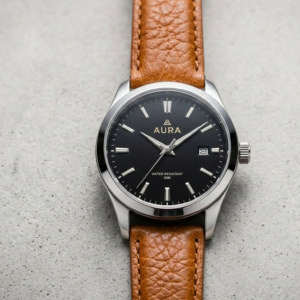 שעון קוורץ אופנתי לגברים עם רצועת עור בצבע חום חם ולוח שעון שחור אלגנטי.